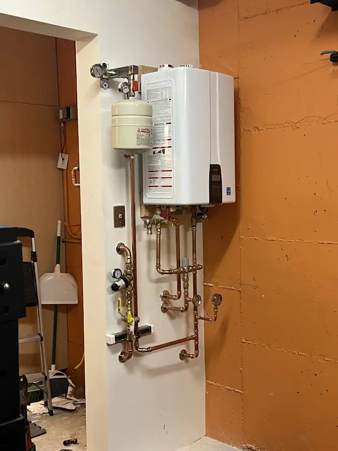 Plumbing technician inspecting water heater connections in Bourbonnais